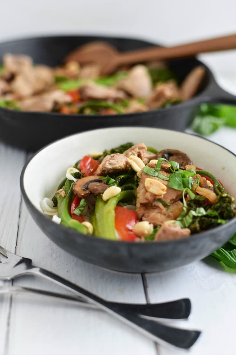 bowl with broccoli, mushrooms, peppers, and pork topped with peanuts 