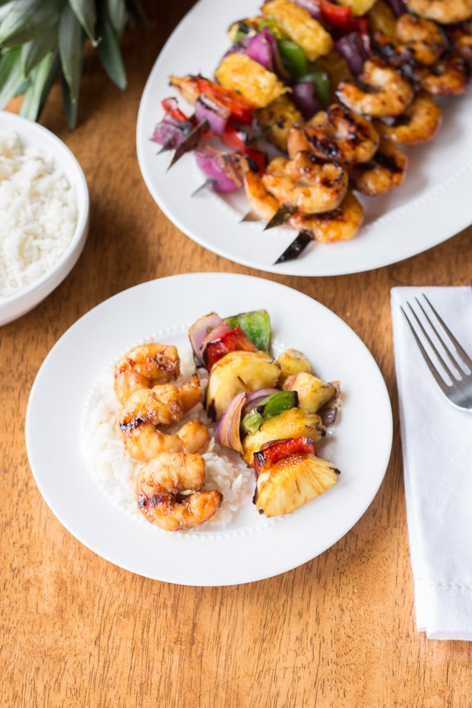 plates on table with rice and shrimp skewers