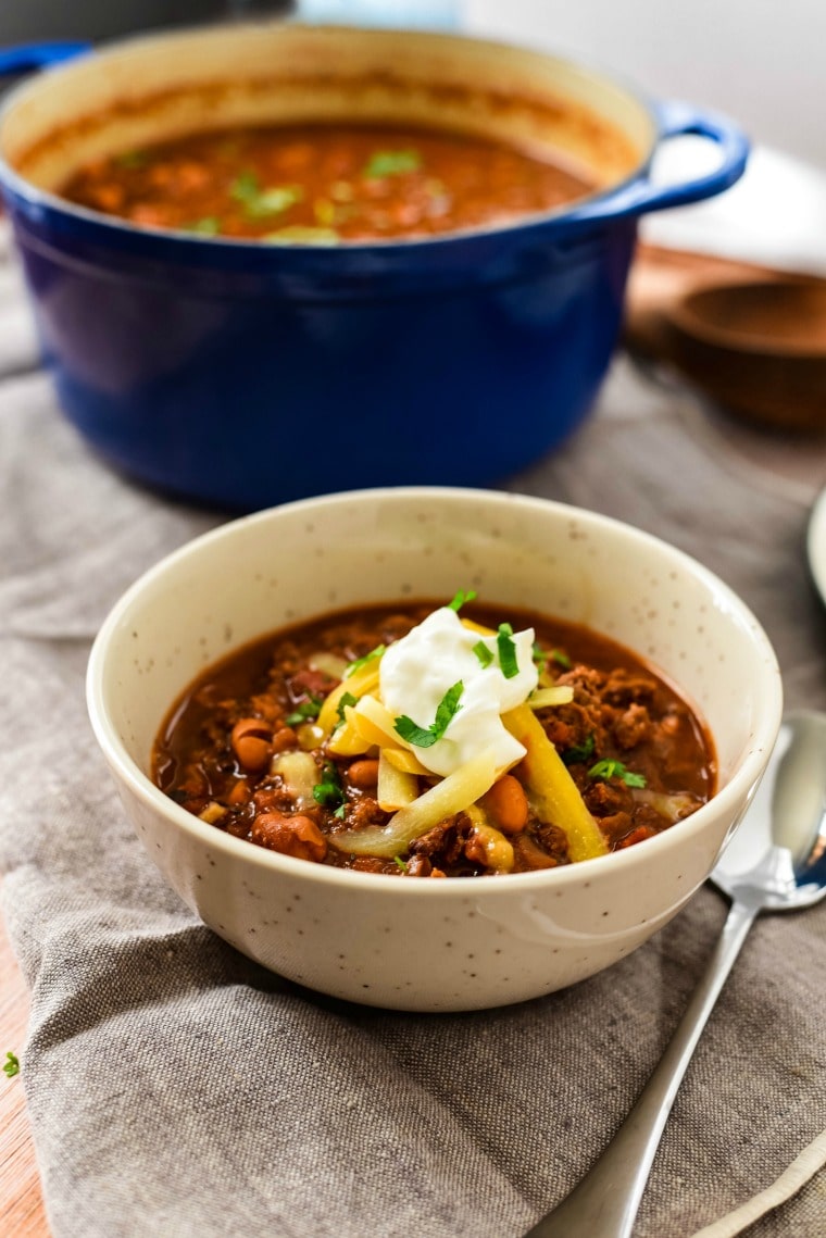 bowl with chili toped with cheese and sour cream
