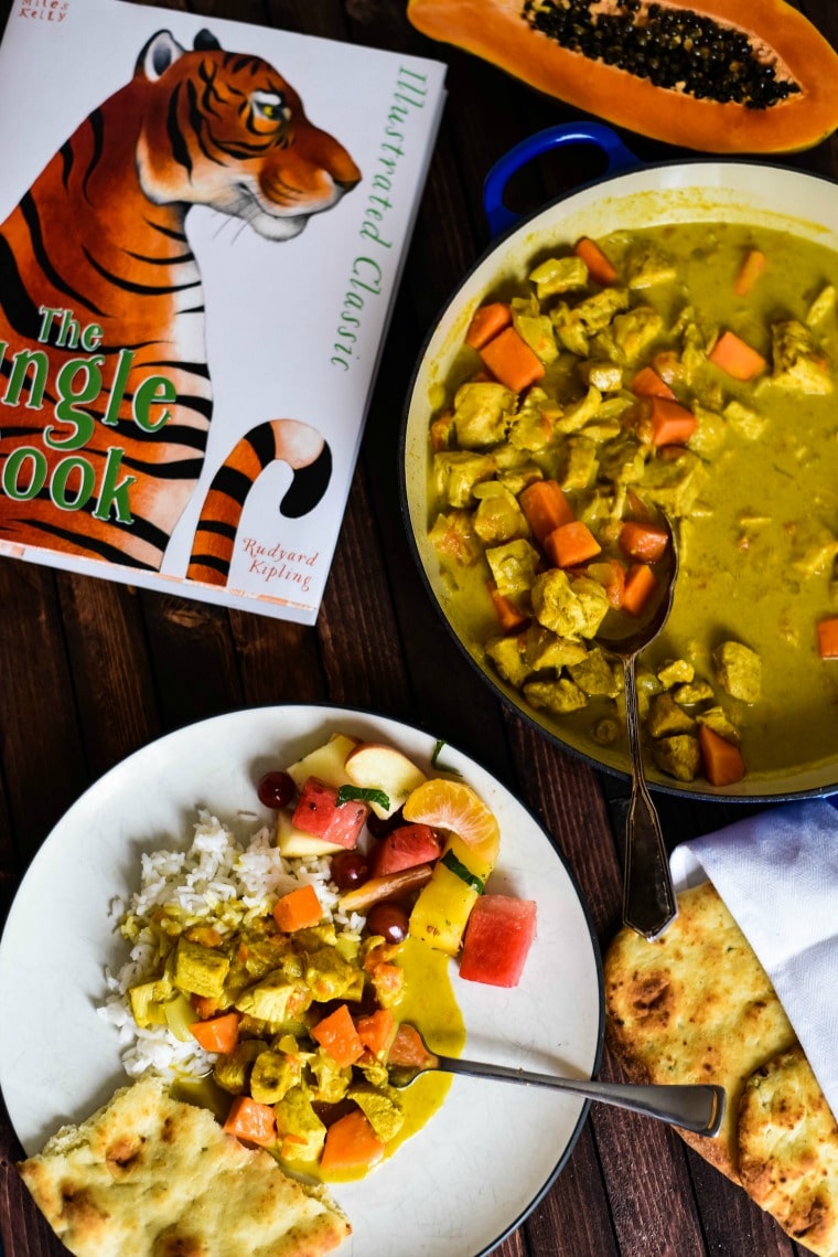 chicken curry with papaya next to book