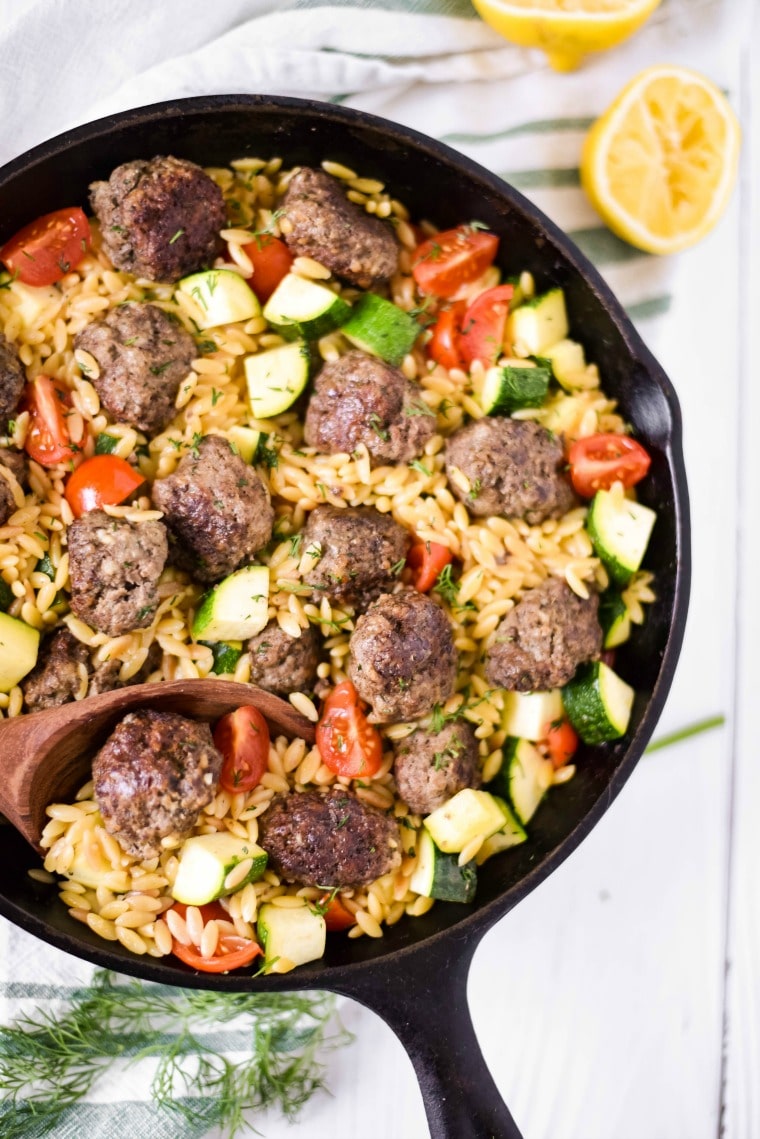 cast iron skillet with meatballs and orzo