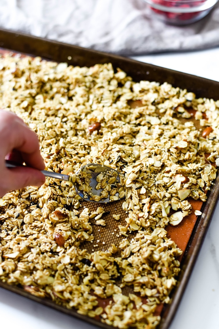 stirring homemade granola on pan 