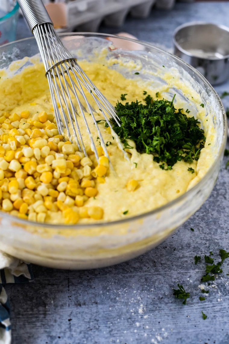 mixing waffle batter with corn and parsley