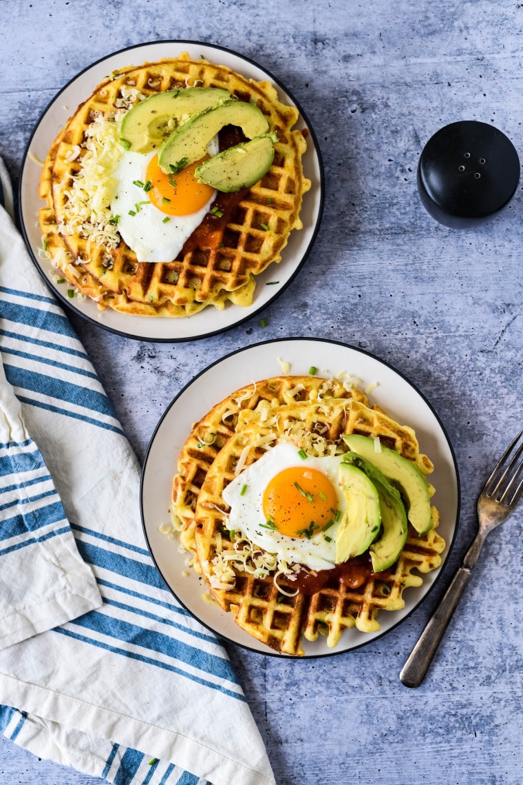 savory waffles topped with fried eggs and avocados