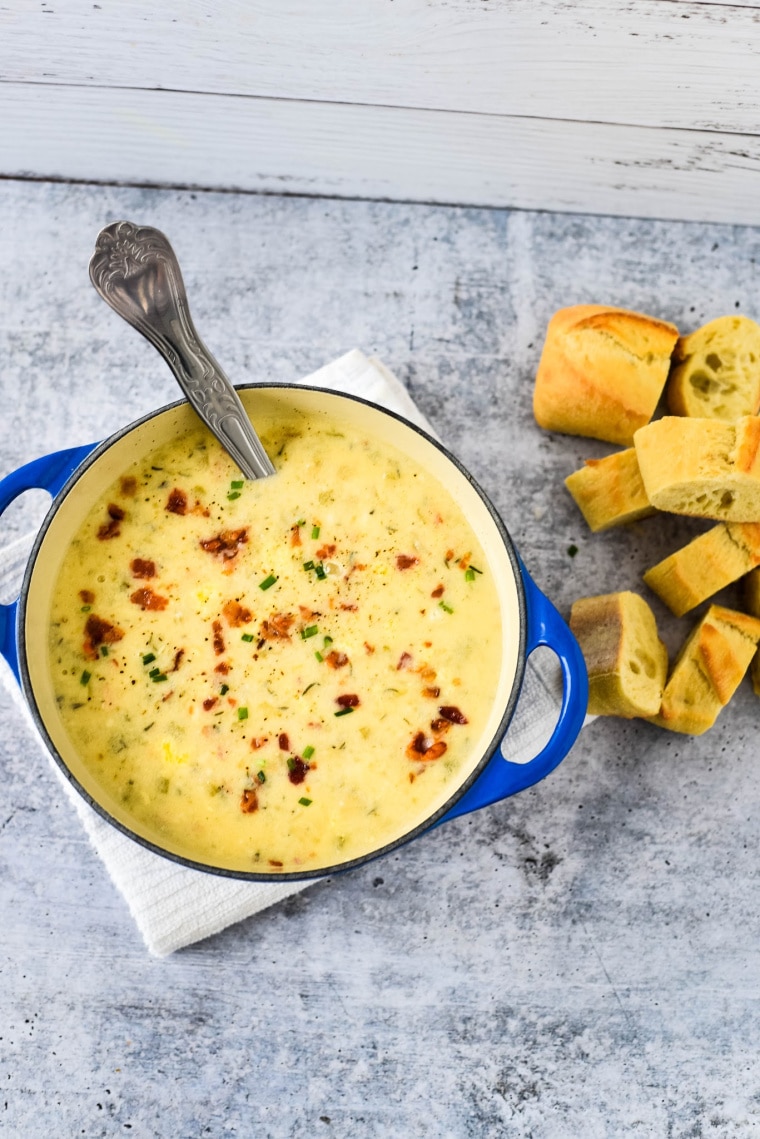 soup in blue bowl with ladle and bread