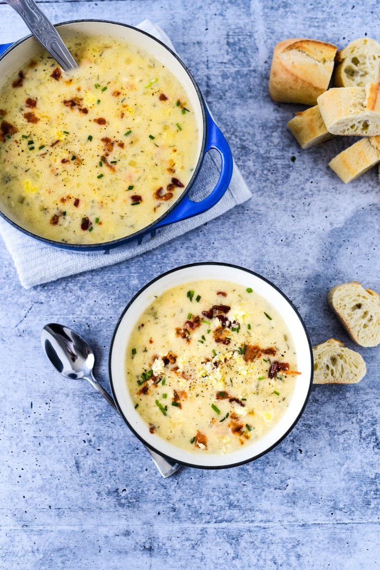 potato soup in bowl with soup in pot behind