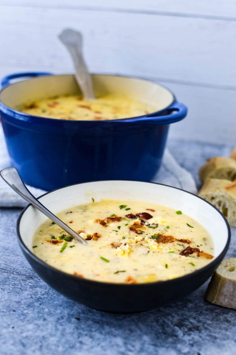 soup in bowl with soup in pot behind