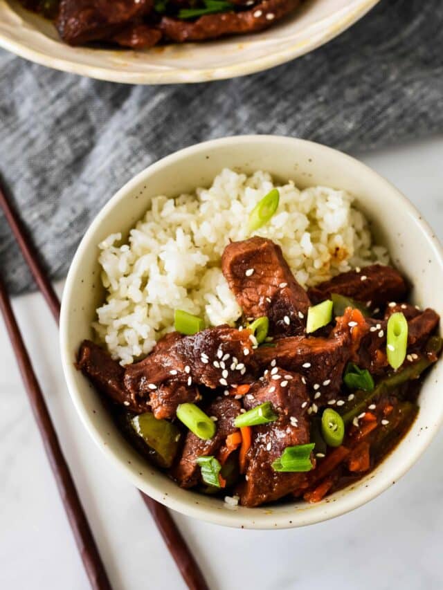 Bowl of Slow Cooker Mongolian Beef with Rice and chopsticks