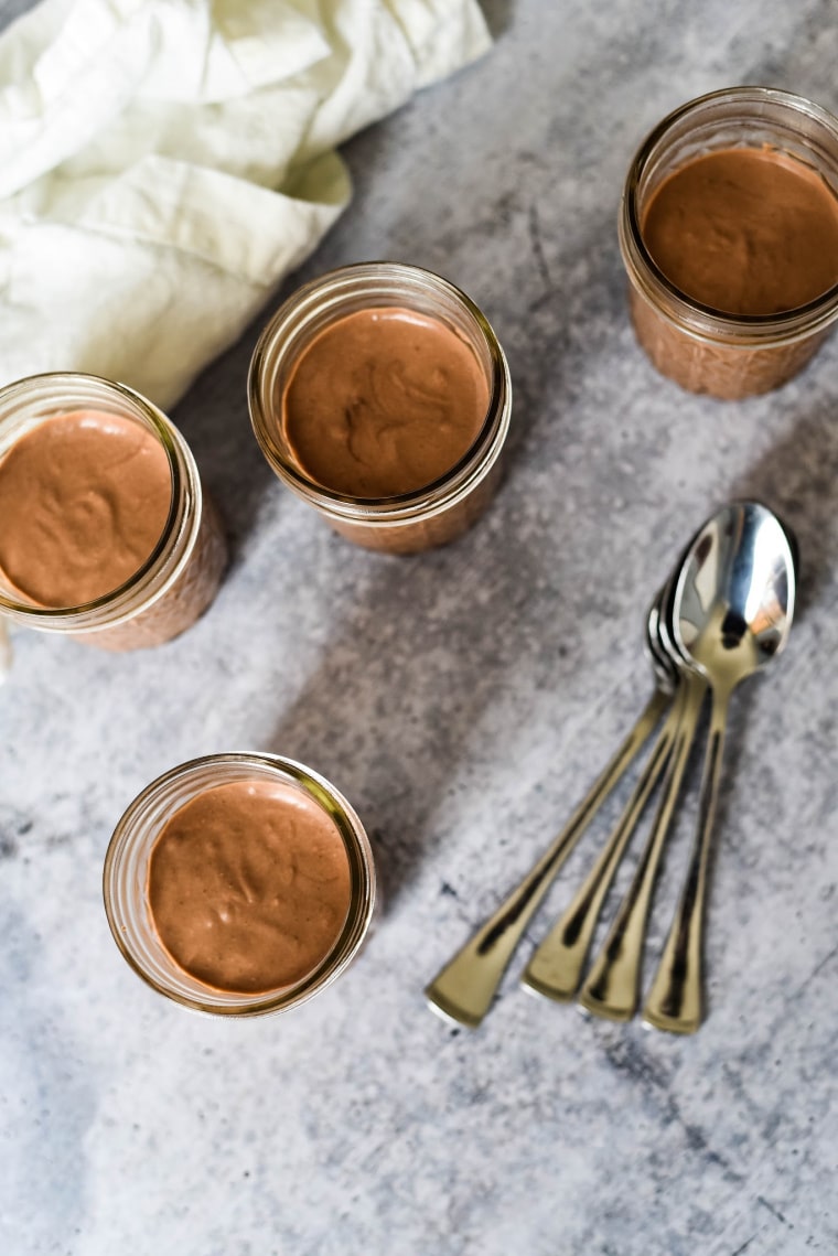 overhead view of 4 panna cotta in jars with spoons