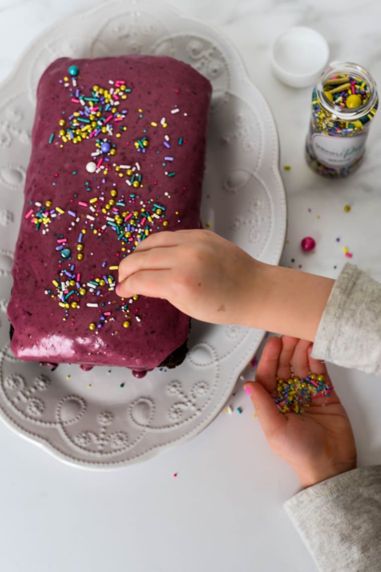 placing sprinkles on chocolate wacky cake