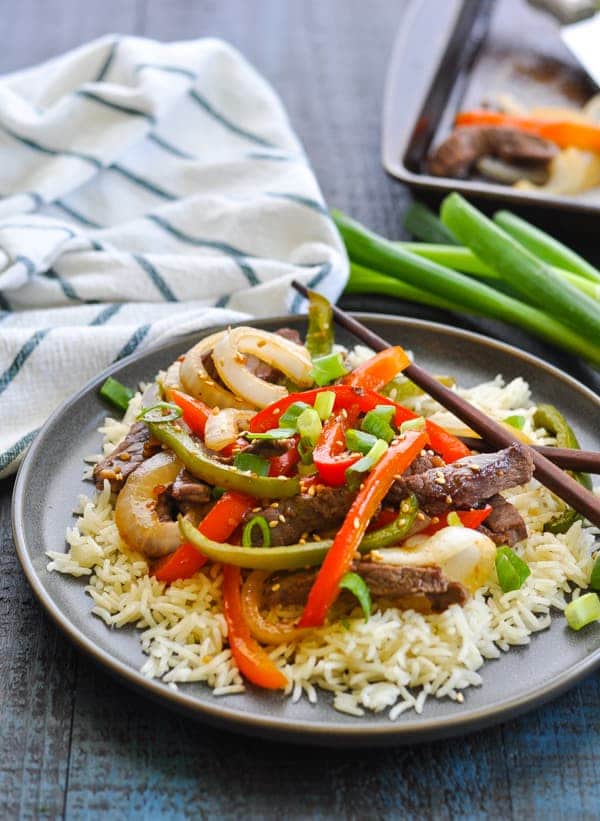 chinese pepper steak recipe with rice on gray plate