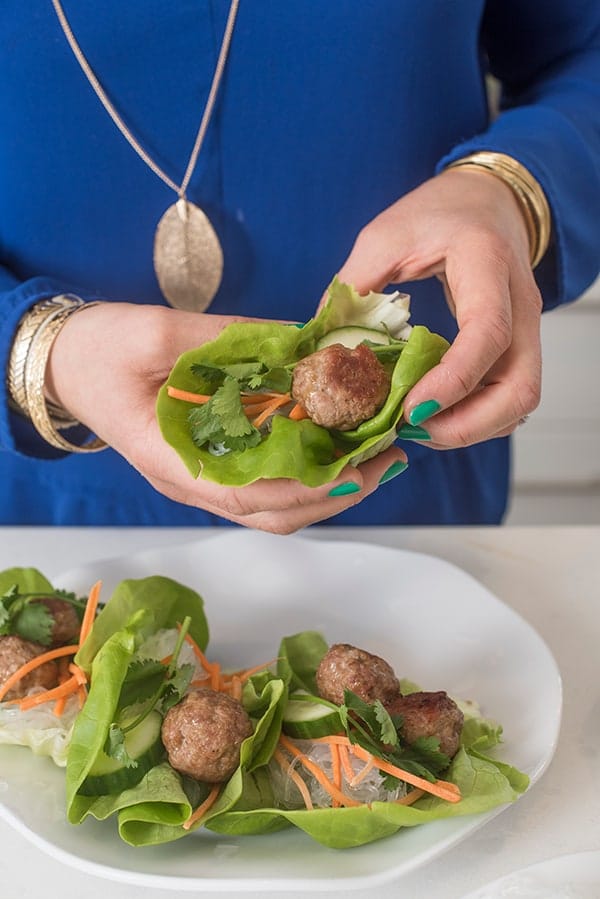 asian meatballs in lettuce wraps held by hand