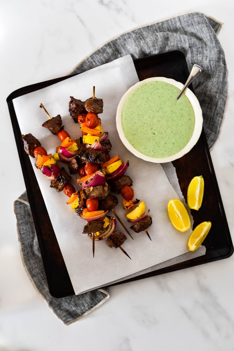 grilled beef kabobs on tray with mint yogurt dipping sauce