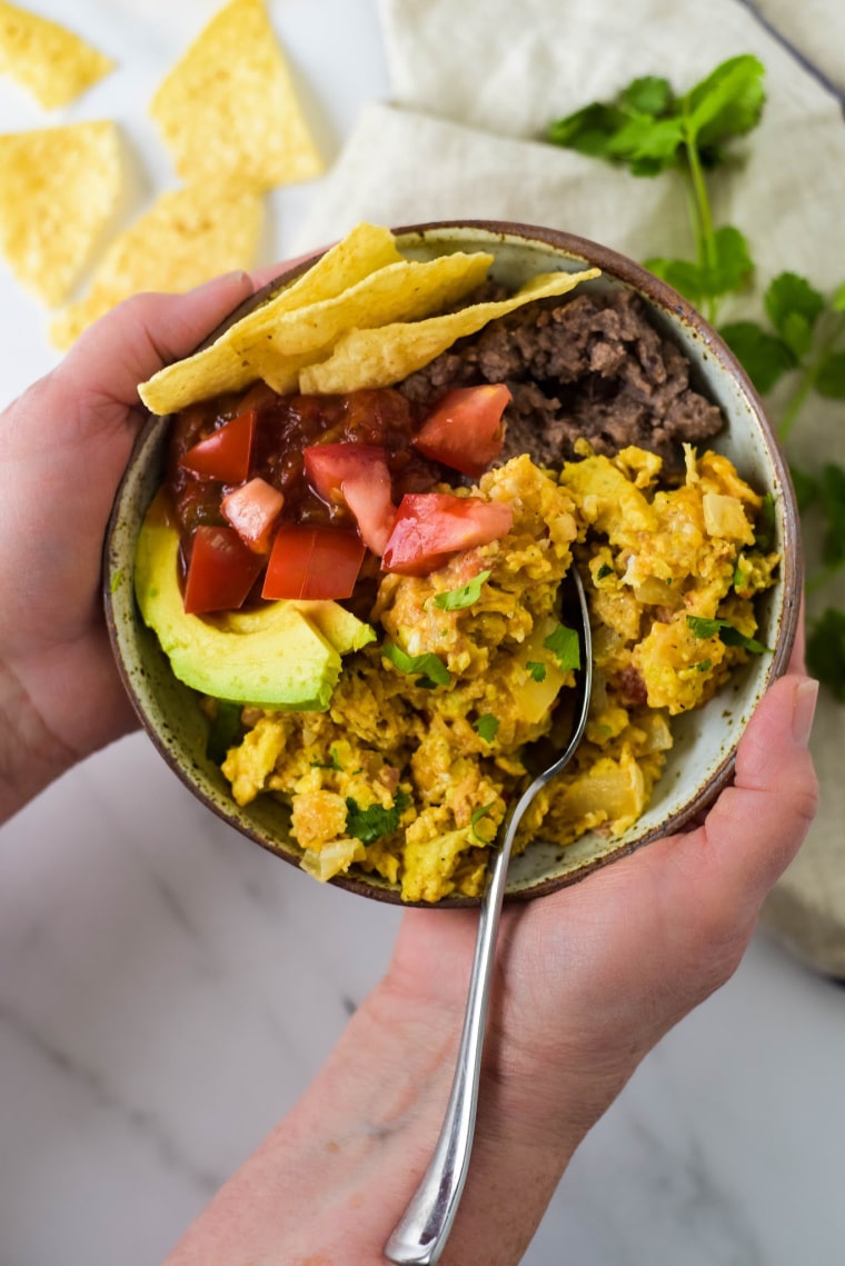 tex mex migas in bowl being held in hands