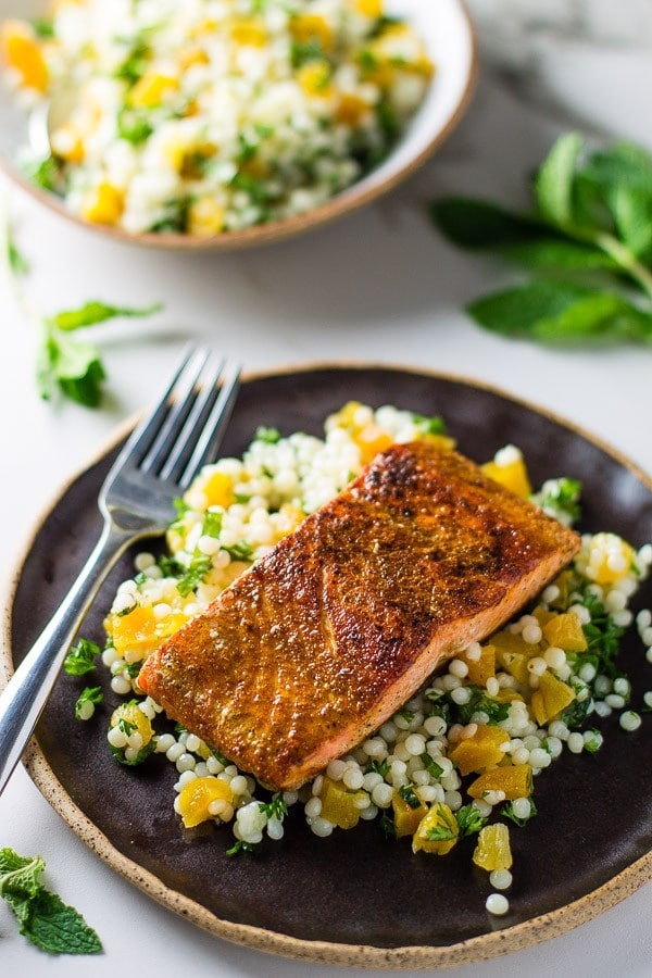 piece of salmon on couscous with orange slices 