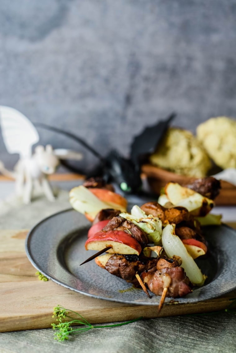 plates with kebobs with apples, lamb, and cabbage