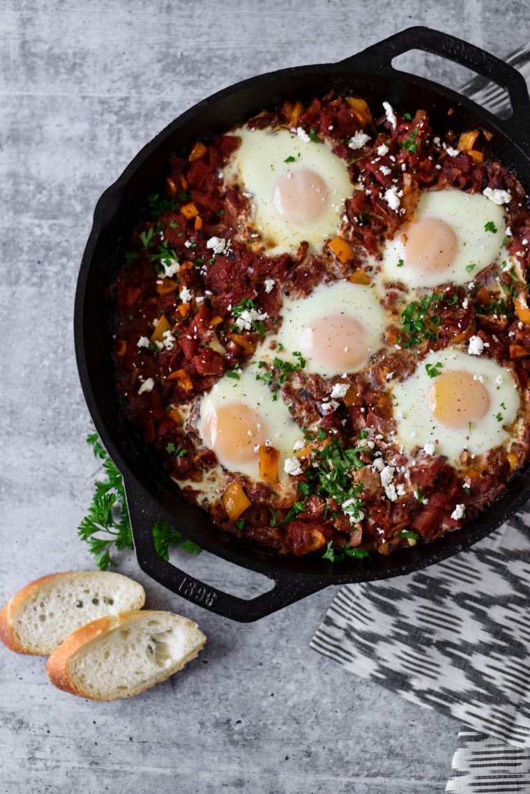 cast iron skillet with tomato sauce and poached eggs