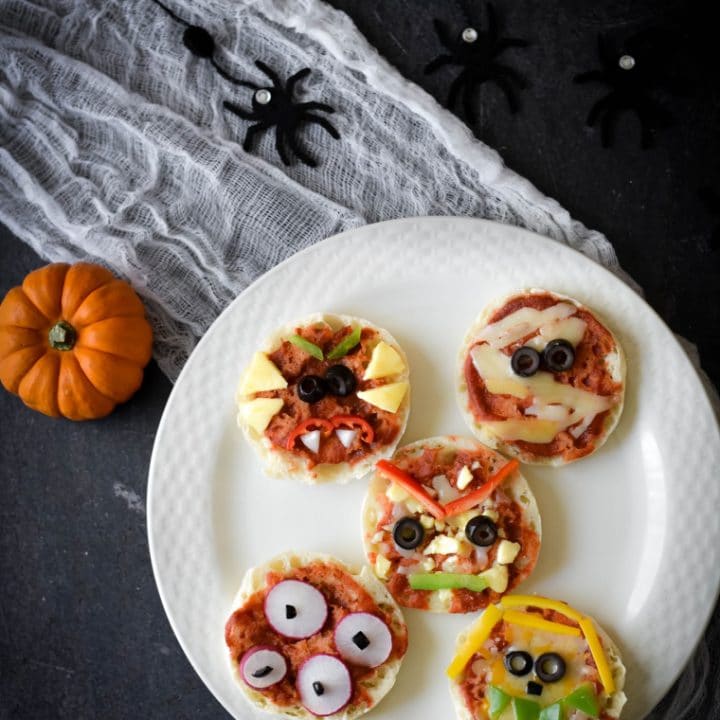 white plate with halloween decorations and mini pizzas