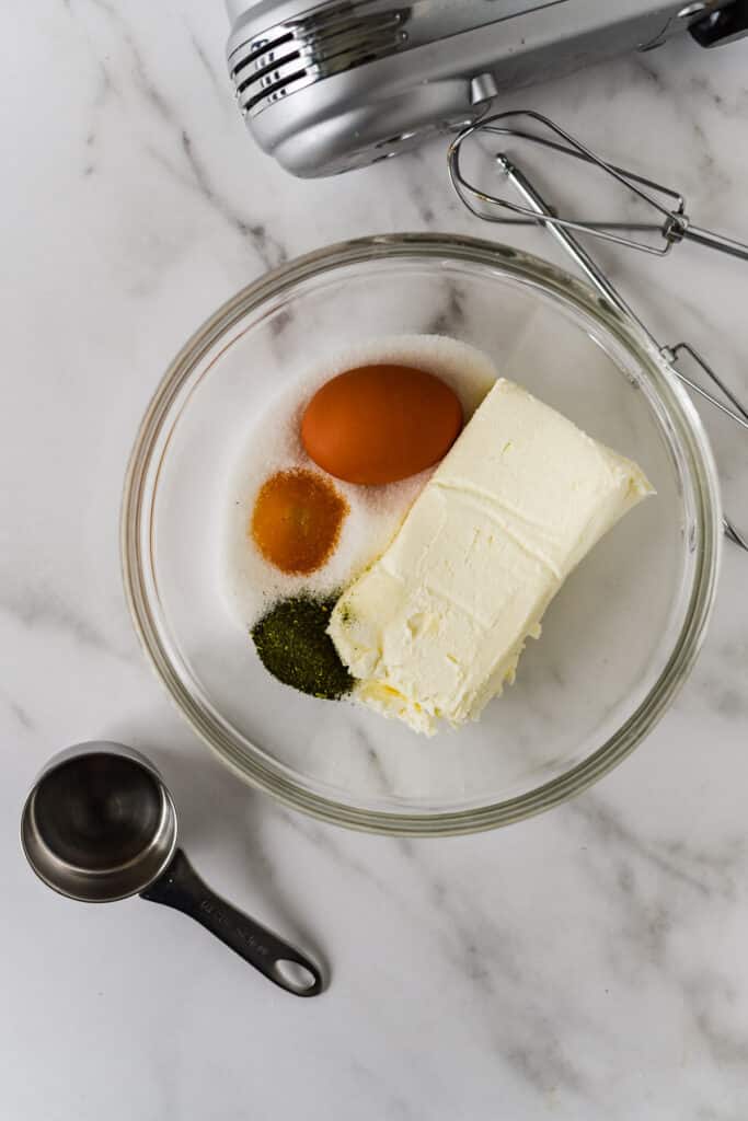 ingredients for matcha cheesecake in glass bowl