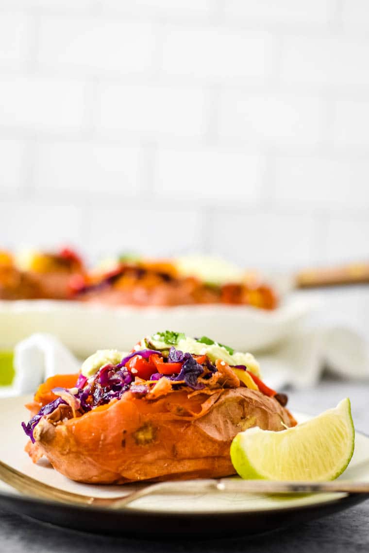 mexican stuffed sweet potato with lime wedge on plate