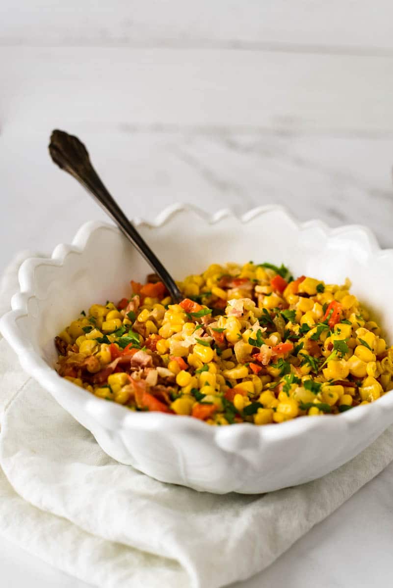 white bowl with cajun corn and spoon