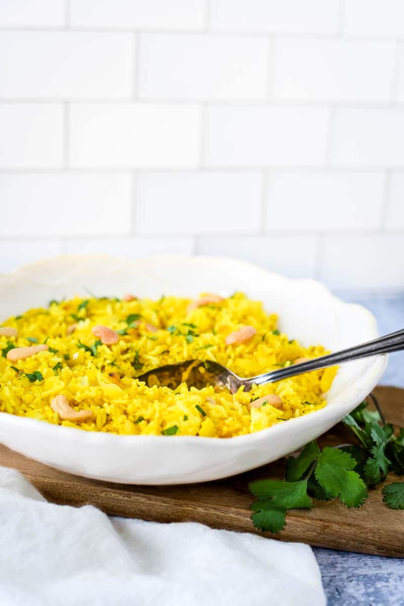 lemon rice in white bowl with spoon