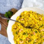overhead view of lemon rice in white bowl with spoon