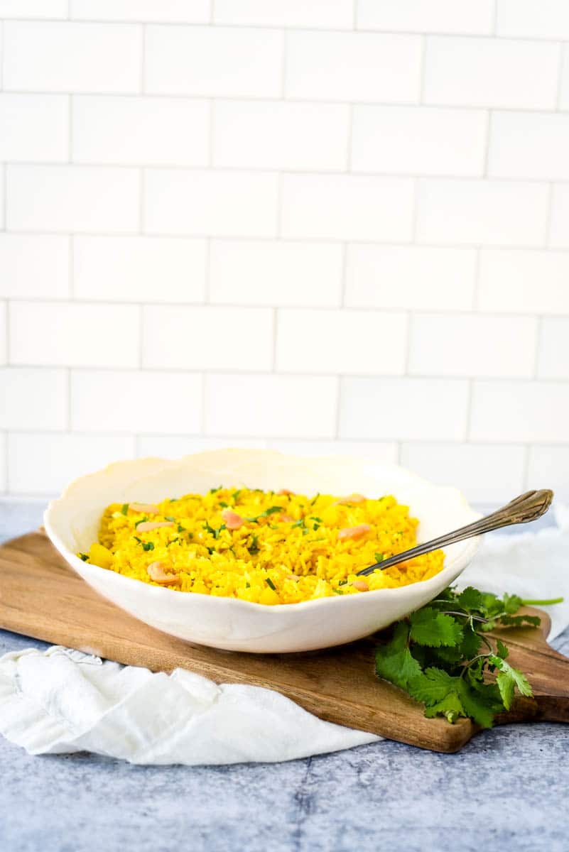 lemon rice recipe in white bowl with kitchen background