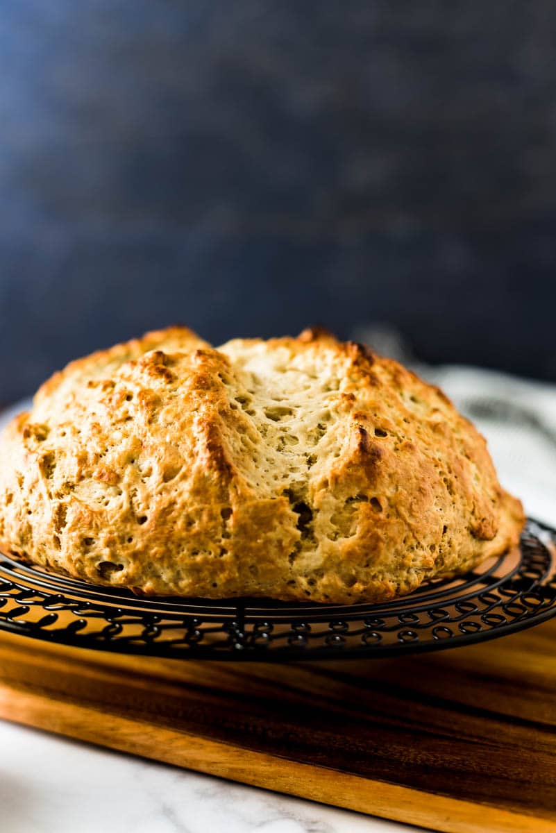 loaf of irish soda bread with sourdough discard on wooden cutting board