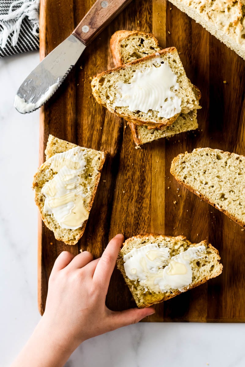 irish soda bread slices with child's hand taking a piece