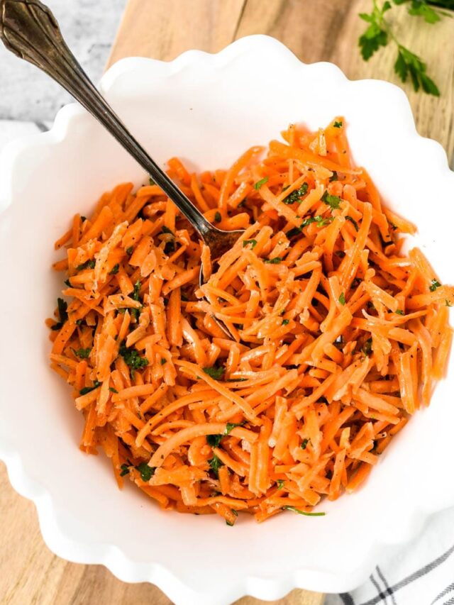 overhead view of shredded french carrots in white bowl