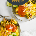 two plates of bobotie with toppings and forks beside. Text overlay of recipe title for Pinterest.
