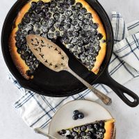 cast iron skillet with clafoutis and blueberries