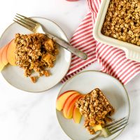 apple baked oatmeal on serving plates with dish behind