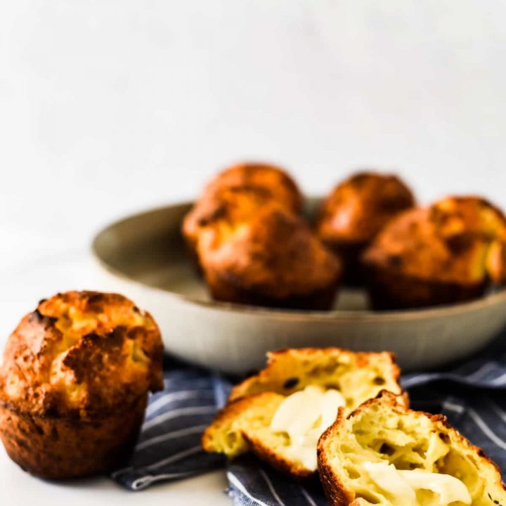 cheese popovers in bowl with one split open with butter