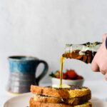 maple syrup being poured on stack of french toast