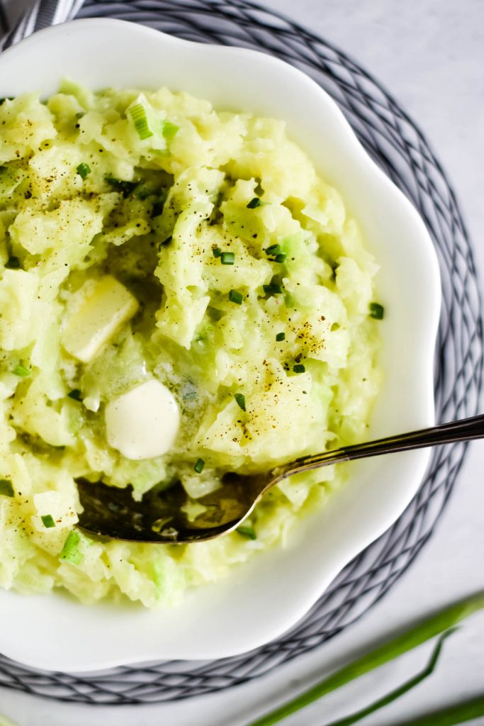 overhead of mashed potatoes with cabbage in serving bowl with spoon