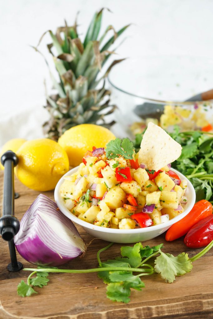 homemade pineapple salsa with ingredients behind