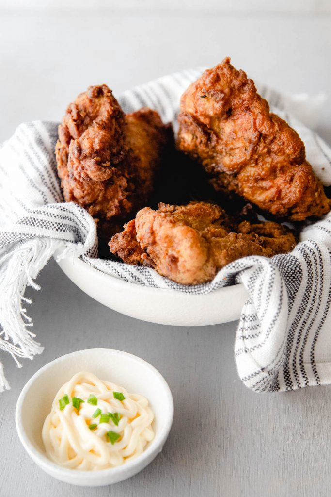 bowl of fried chicken with bowl of mayo beside