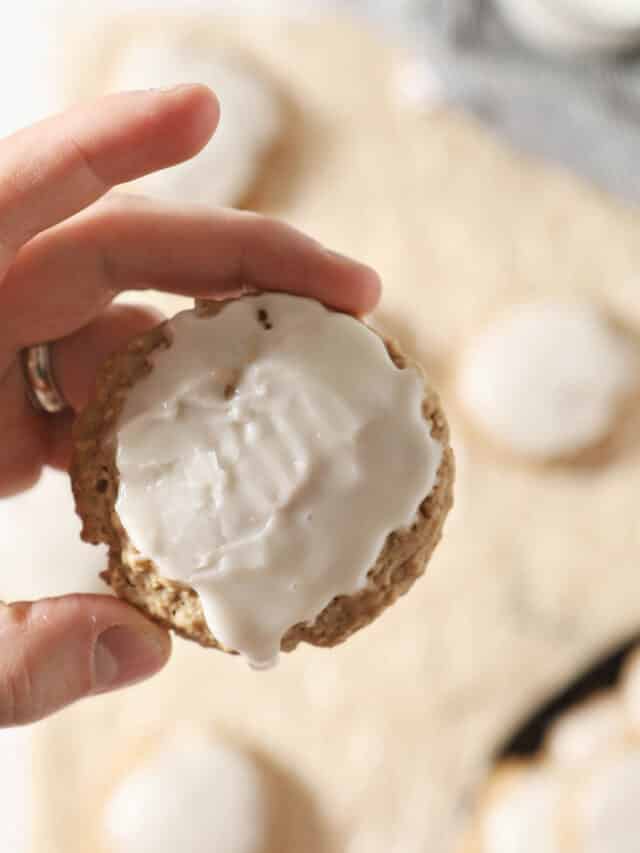 hand holding iced oatmeal cookie with sourdough discard