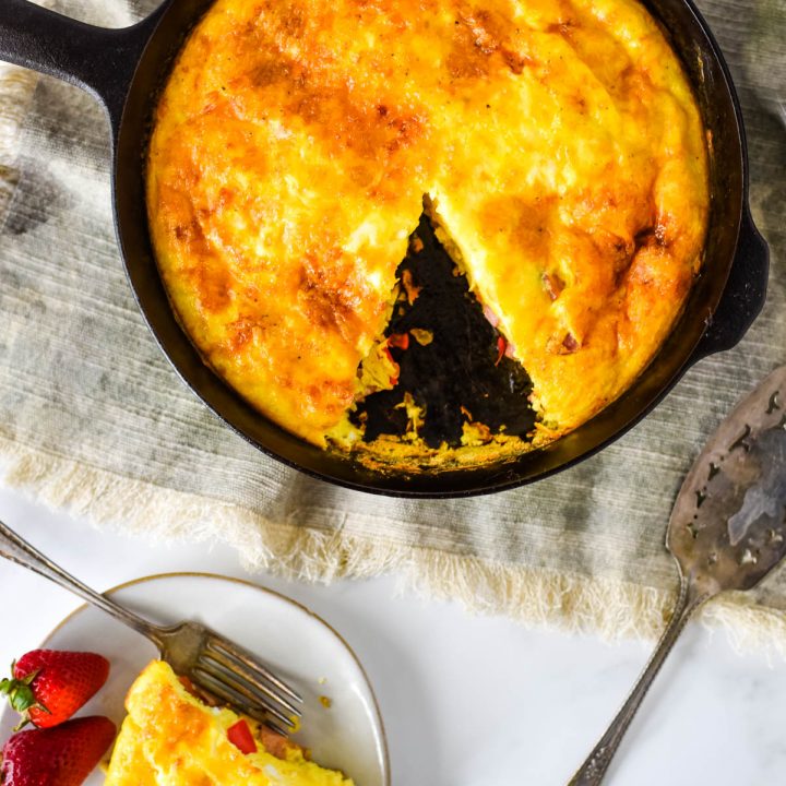 overhead view of cast iron skillet with frittata and small plate beside