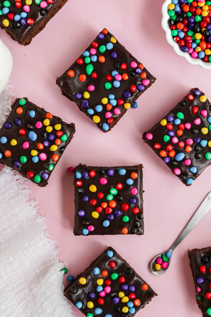 brownies with candy sprinkles on pink board