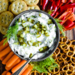 pickle dip in bowl surrounded by crackers and veggies