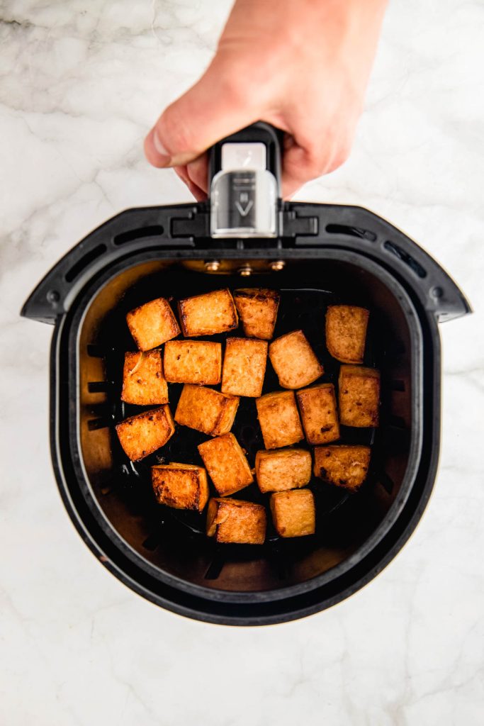 air fryer basket filled with tofu cubes