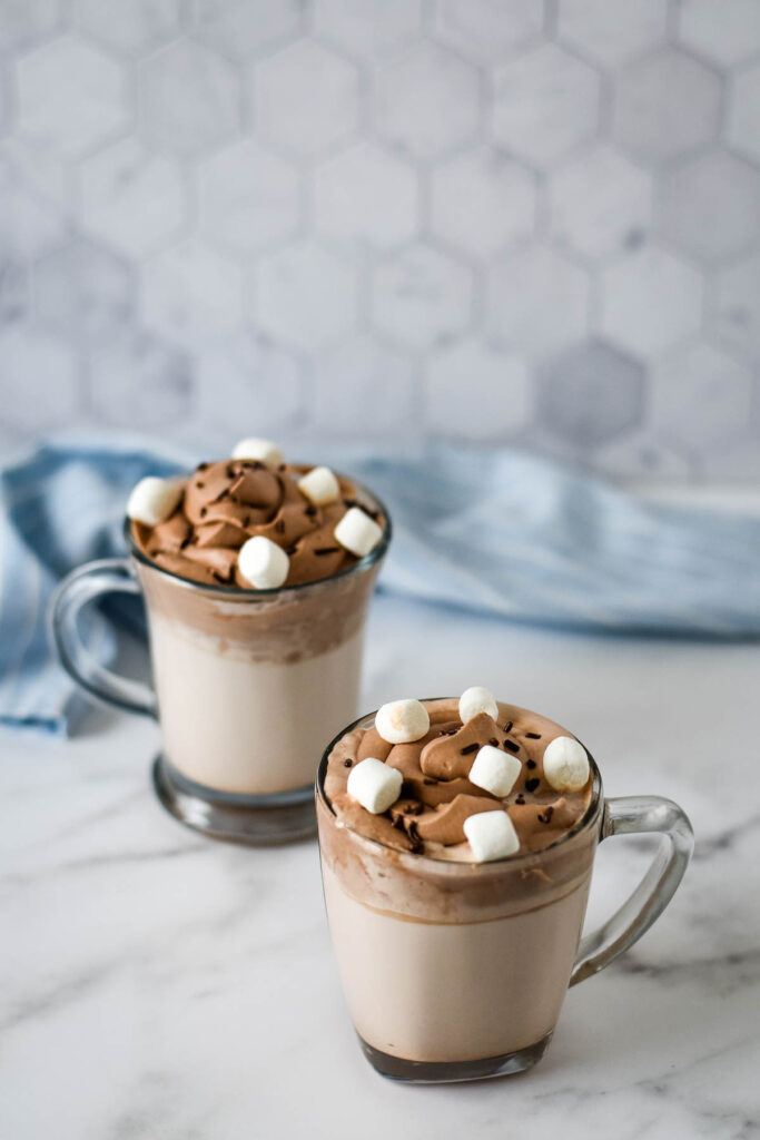 two mugs of whipped hot chocolate with marshmallows