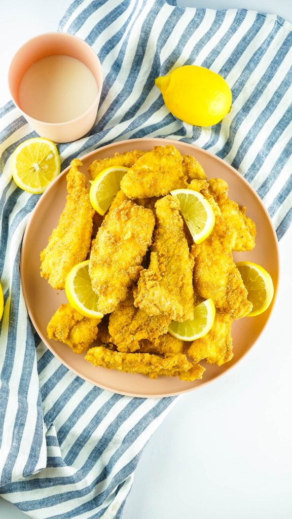 overhead image of southern fried catfish on platter with lemon and tartar sauce