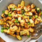 diced roasted japanese sweet potatoes in bowl with serving spoon