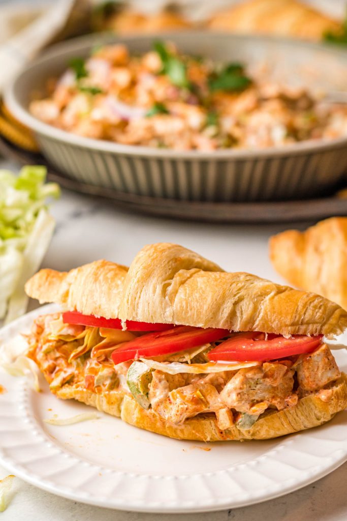 cajun chicken sandwich on croissant with sliced tomatoes and lettuce