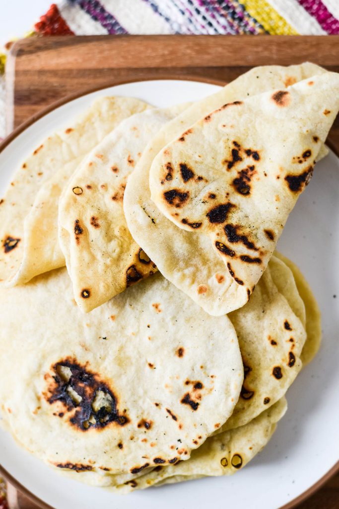 homemade tortillas curled on white plate