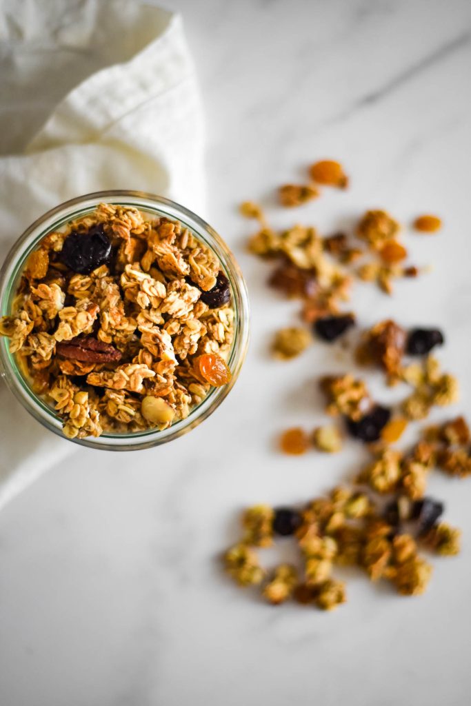 overhead image of granola in jar and sprinkled on counter